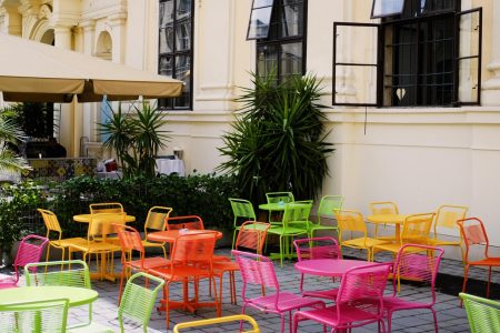 a group of colorful tables and chairs outside a building